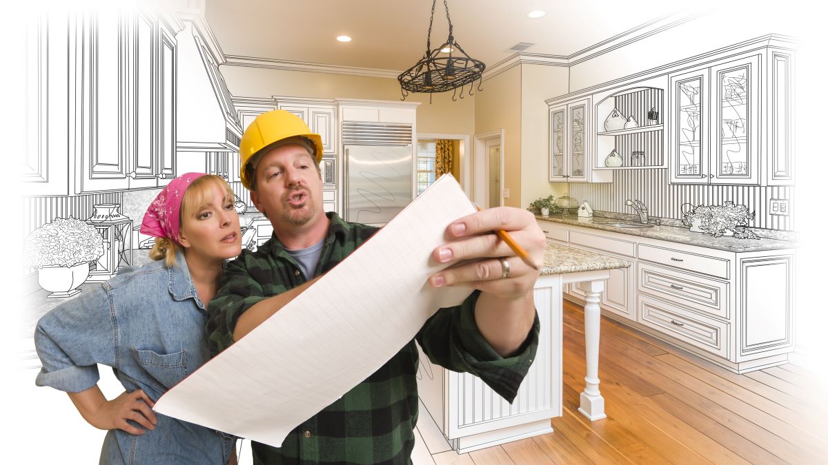 contractor in hard hat going over plans with home owner