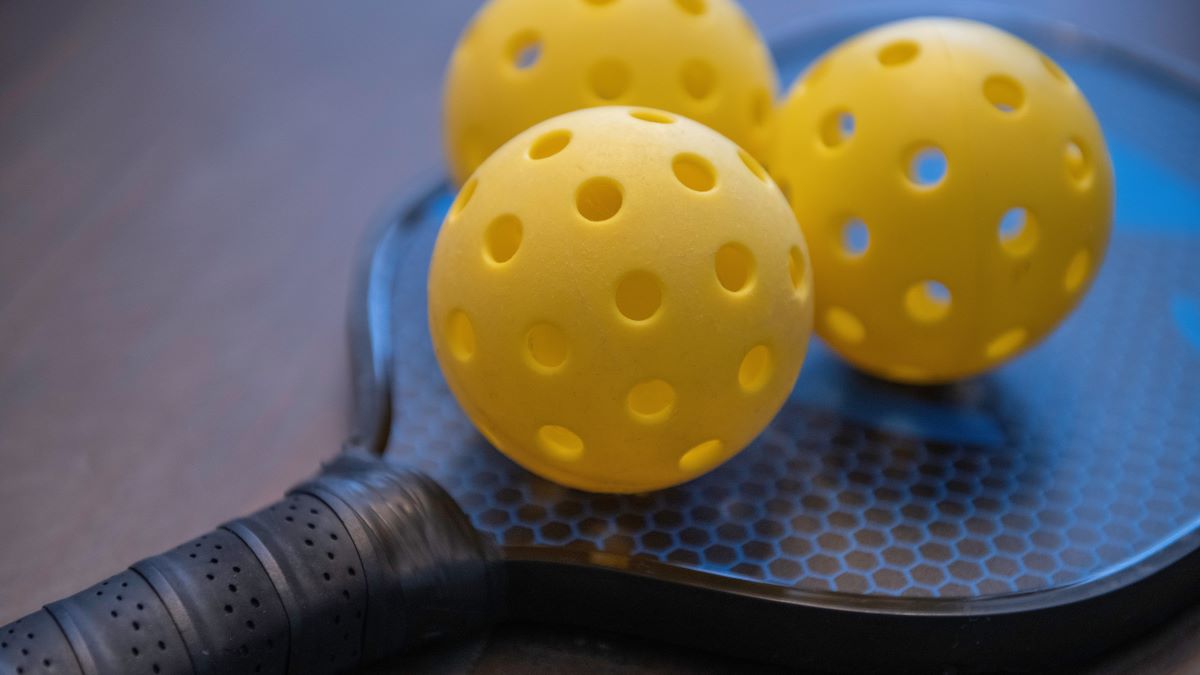 3 pickelballs on a paddle