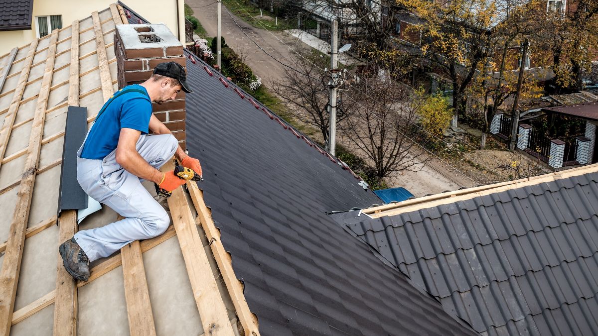 Roofer replaces metal roof on house