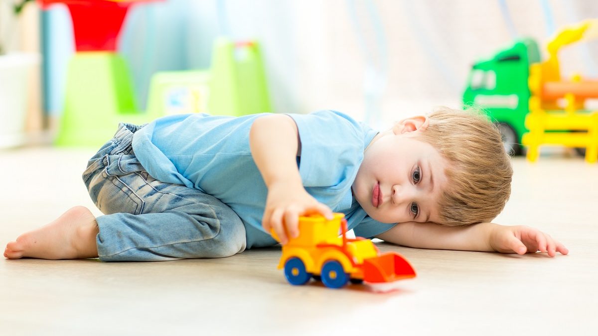 boy toddler playing with plastic toy car