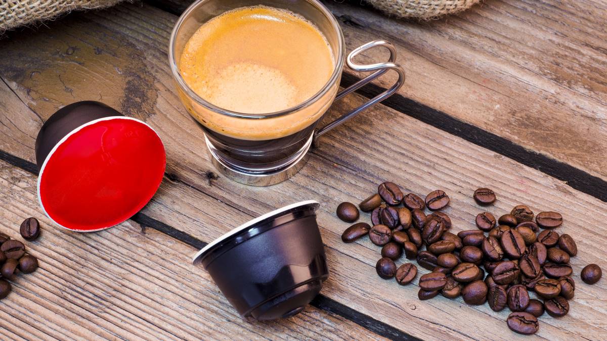 cup of coffee and single-serve coffee pods on wooden table