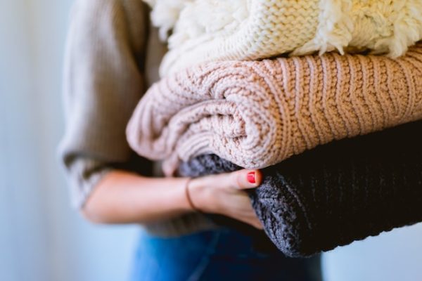 person holding a stack of blankets