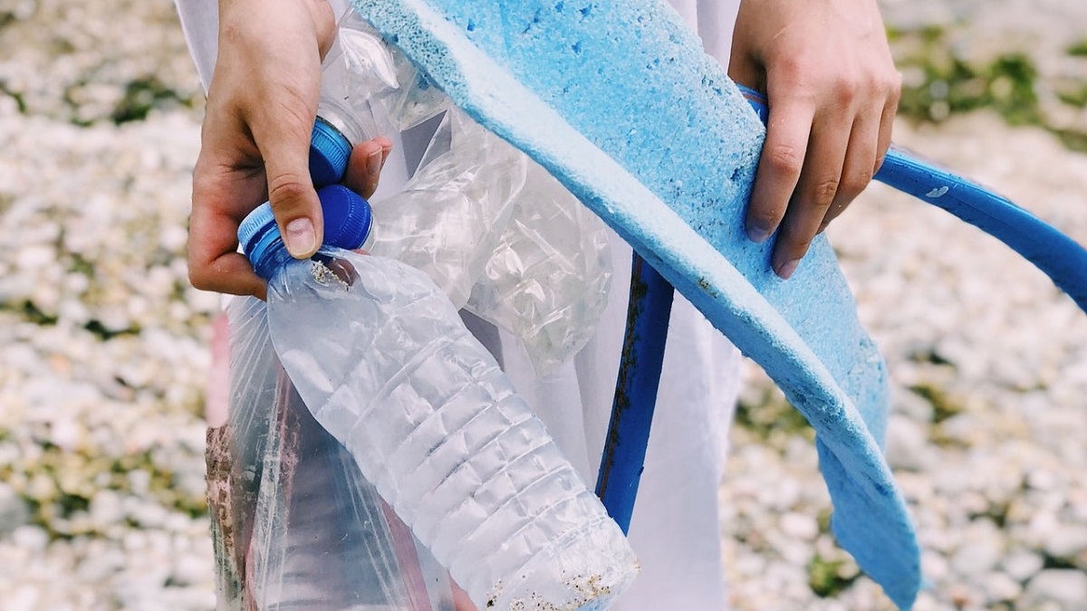 person holding trash picked up on beach